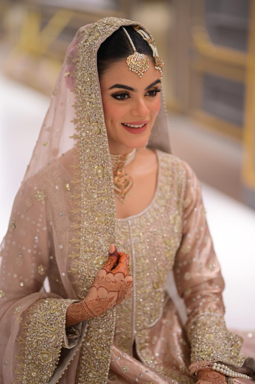 Blush pink Pakistani bridal reception lehenga by MariamRaj with embroidered tissue gown, matching lehenga, and net dupatta – ideal for valima and wedding events.