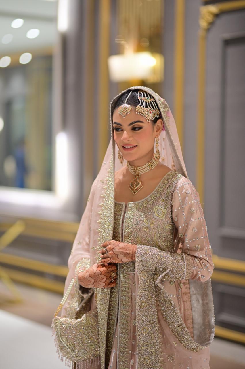 Blush pink Pakistani bridal reception lehenga by MariamRaj with embroidered tissue gown, matching lehenga, and net dupatta – ideal for valima and wedding events.