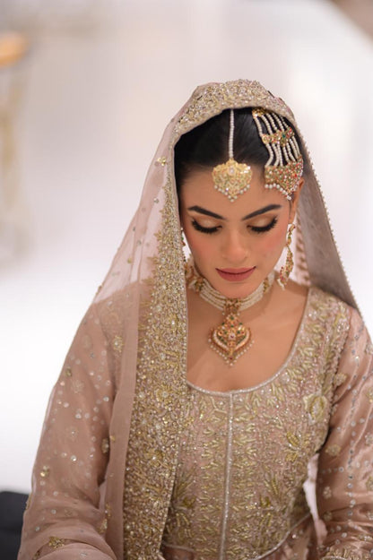 Blush pink Pakistani bridal reception lehenga by MariamRaj with embroidered tissue gown, matching lehenga, and net dupatta – ideal for valima and wedding events.