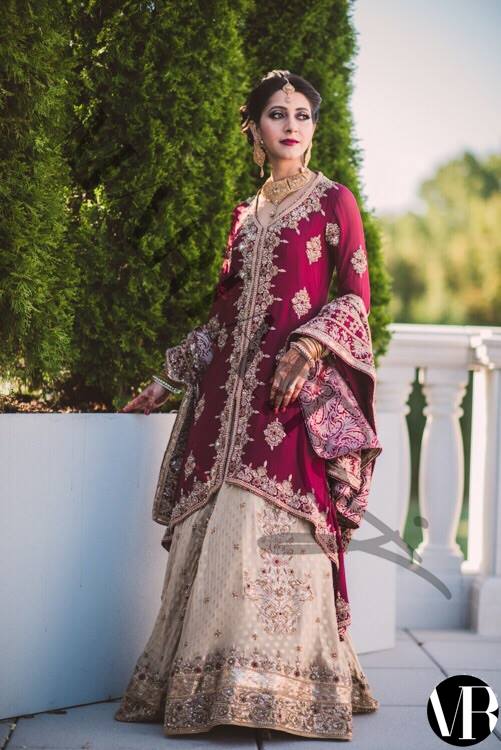 Deep red Pakistani bridal lehenga by MariamRaj with maroon embroidered hi-low shirt, golden banarsi chiffon lehenga, and embroidered dupatta – ideal for weddings and baraat events.