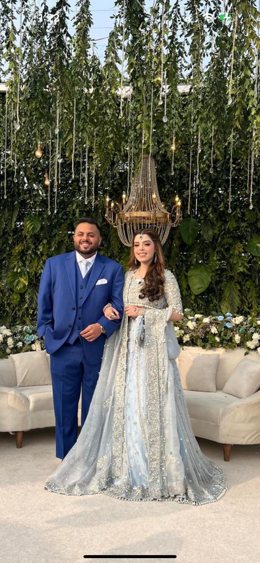 Elsa – Ice blue Pakistani bridal lehenga by MariamRaj featuring a hand-embroidered raw silk blouse with tassels, net lehenga with intricate motifs, and a fully embellished net organza dupatta. Custom stitched for Pakistani brides in USA and UK.