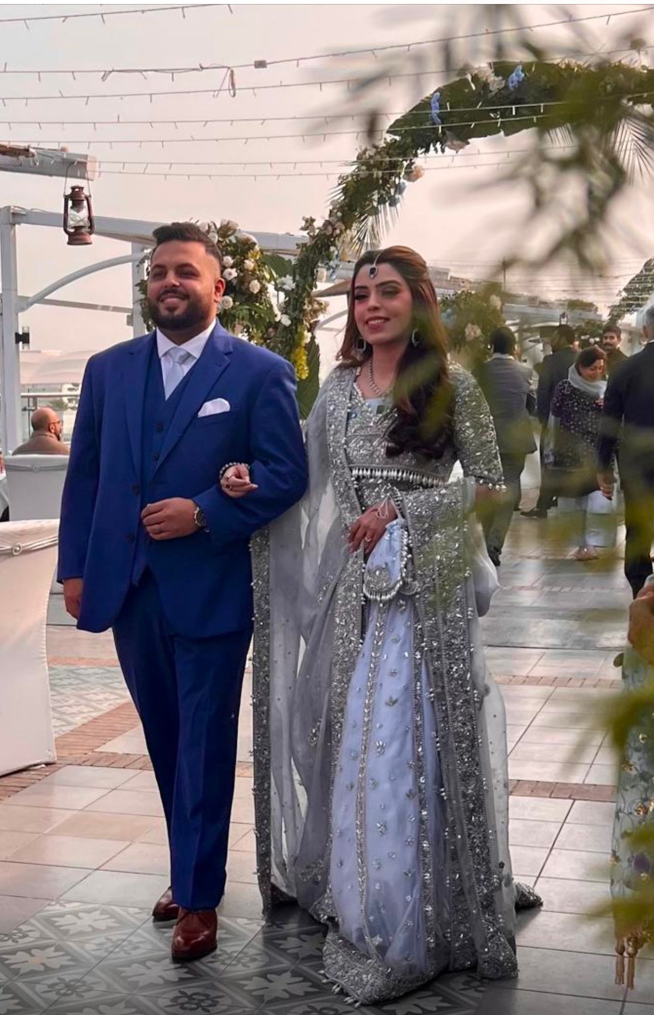 Elsa – Ice blue Pakistani bridal lehenga by MariamRaj featuring a hand-embroidered raw silk blouse with tassels, net lehenga with intricate motifs, and a fully embellished net organza dupatta. Custom stitched for Pakistani brides in USA and UK.