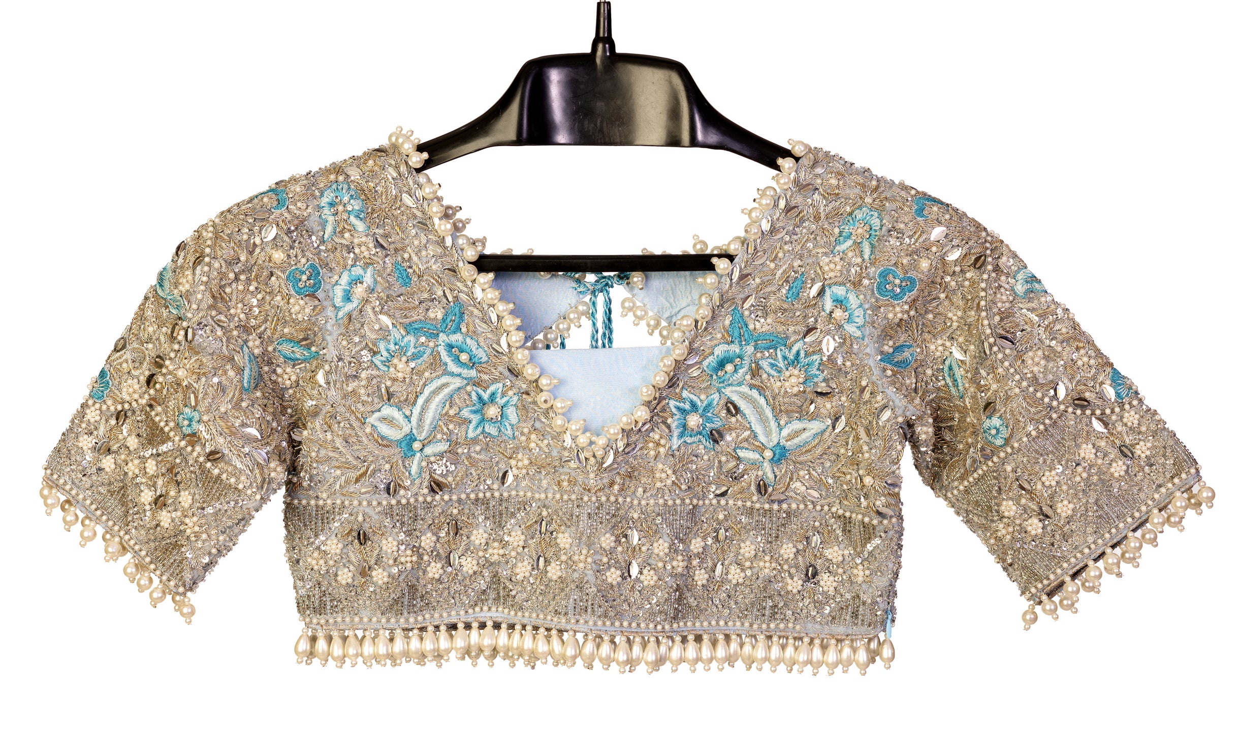 Elsa – Ice blue Pakistani bridal lehenga by MariamRaj featuring a hand-embroidered raw silk blouse with tassels, net lehenga with intricate motifs, and a fully embellished net organza dupatta. Custom stitched for Pakistani brides in USA and UK.

