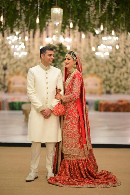 Red bridal farshi gharara by MariamRaj featuring embroidered raw silk kameez, brocade silk gharara, and embellished khaadi silk dupatta – ideal for baraat and Pakistani weddings.
