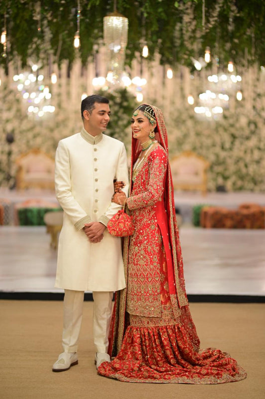 Red bridal farshi gharara by MariamRaj featuring embroidered raw silk kameez, brocade silk gharara, and embellished khaadi silk dupatta – ideal for baraat and Pakistani weddings.